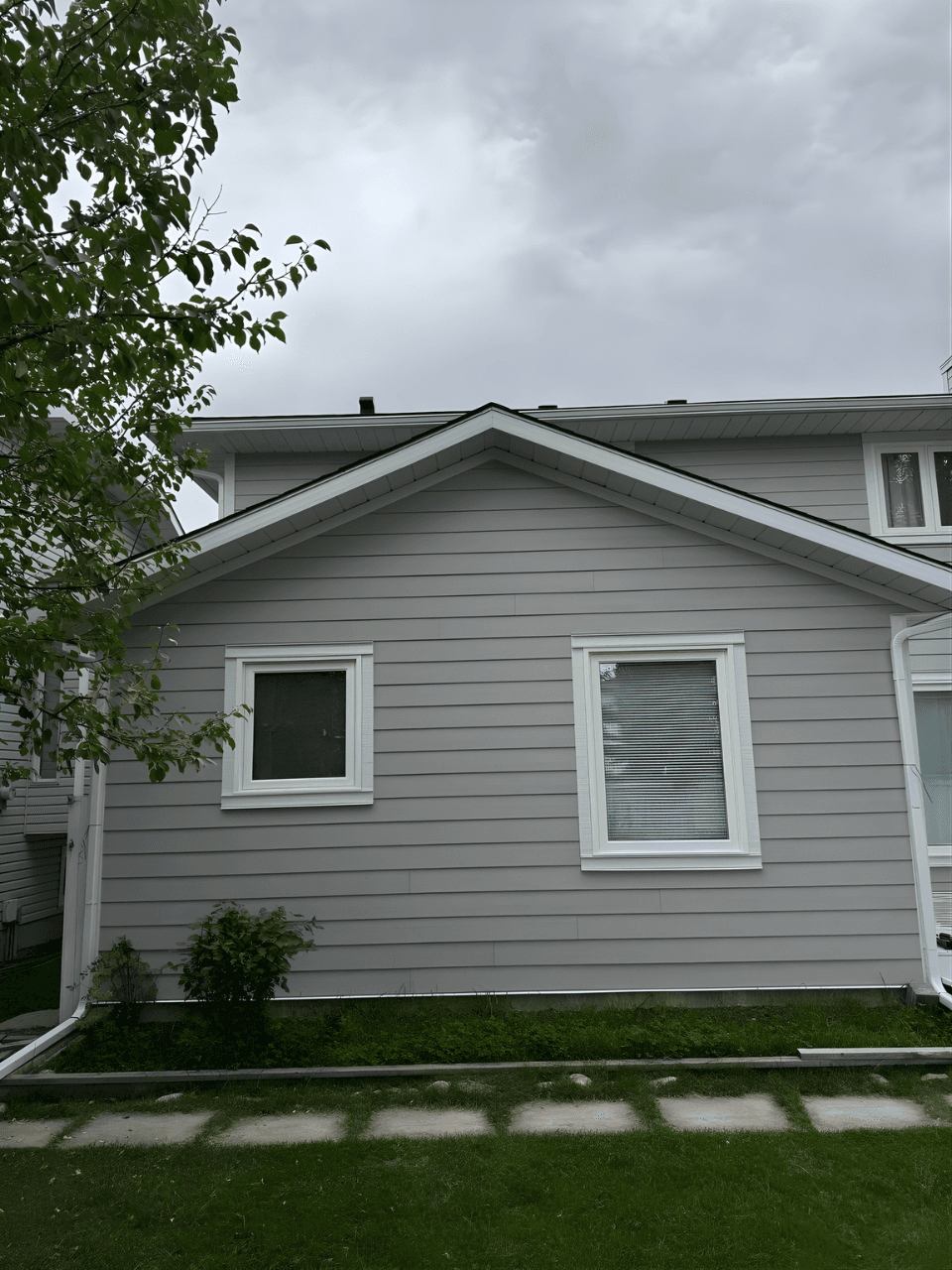 Exterior renovation combining James Hardie siding in Pearl Grey with LP SmartTrim in Arctic White. A balanced, modern color palette paired with durable materials for a sharp, long-lasting finish.