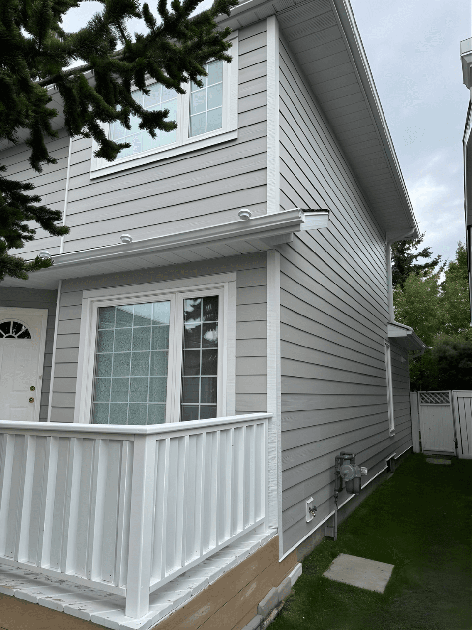 Exterior renovation combining James Hardie siding in Pearl Grey with LP SmartTrim in Arctic White. A balanced, modern color palette paired with durable materials for a sharp, long-lasting finish.