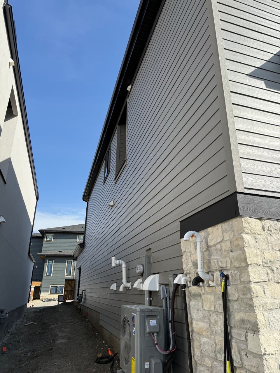 Ground-up exterior installation with a contemporary composition of Hardie panels, board and batten accents, and aluminum roofline details. The palette and textures are selected for clean curb appeal and long-term weather performance.