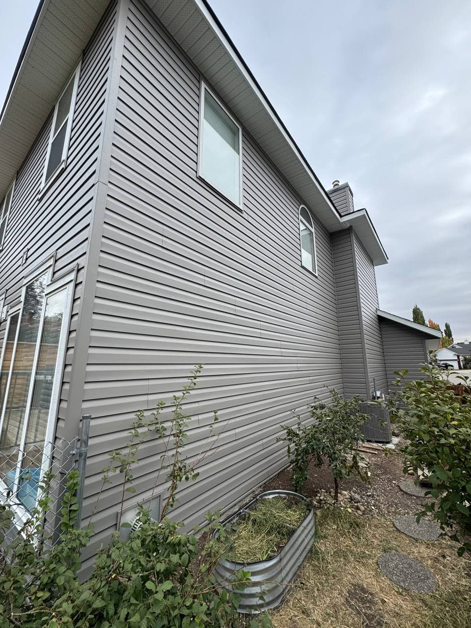 Old vinyl removal and renovation project with new vinyl installation and board-and-batten accent details. The work includes removing the old siding, preparing the surface, and adding clean, modern finishes to improve the look of the house.